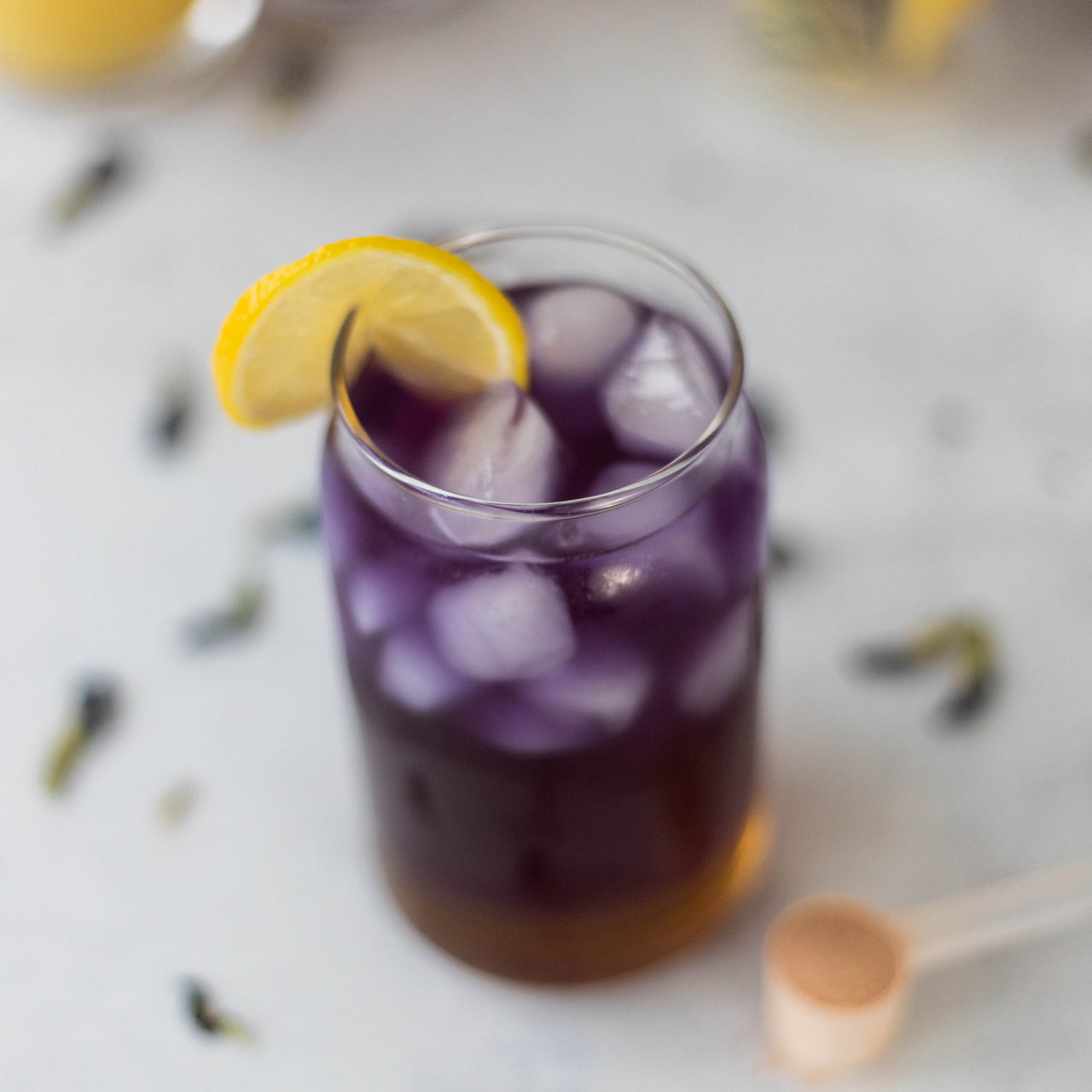 Butterfly Pea Tea Spritz in glass with lemon wedge