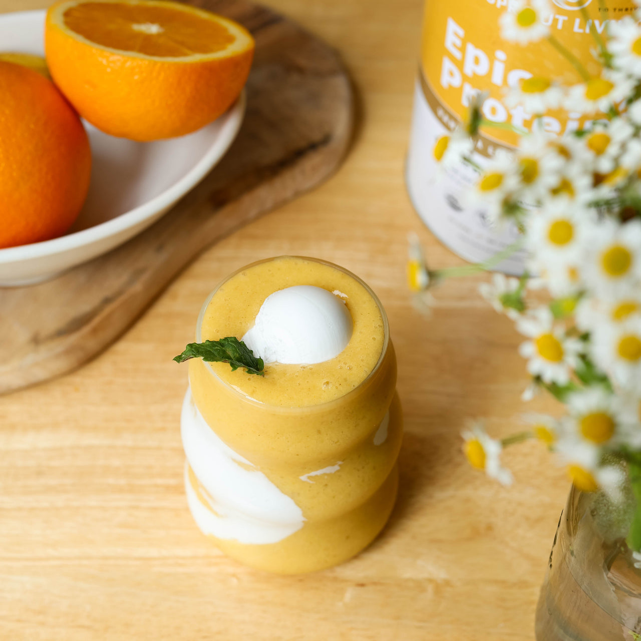 Orange and white smoothie in glass with protein powder