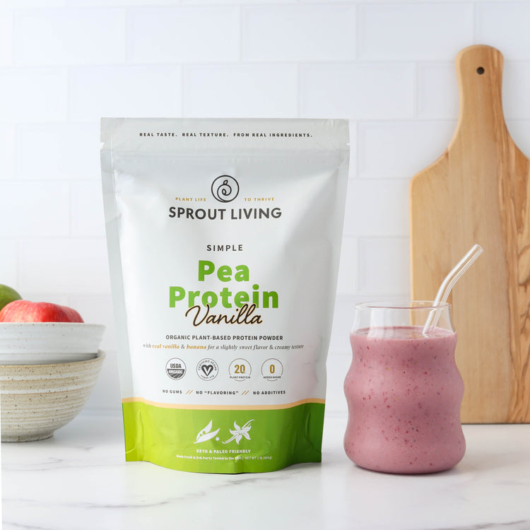 Simple Pea Protein Vanilla with pink smoothie in kitchen