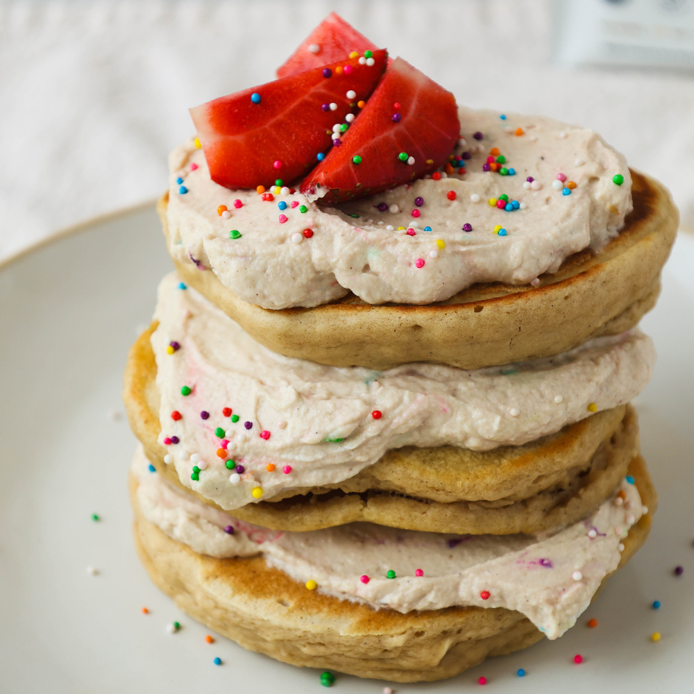 Stack of High Protein Dunkaroo Pancakes on a plate with strawberries