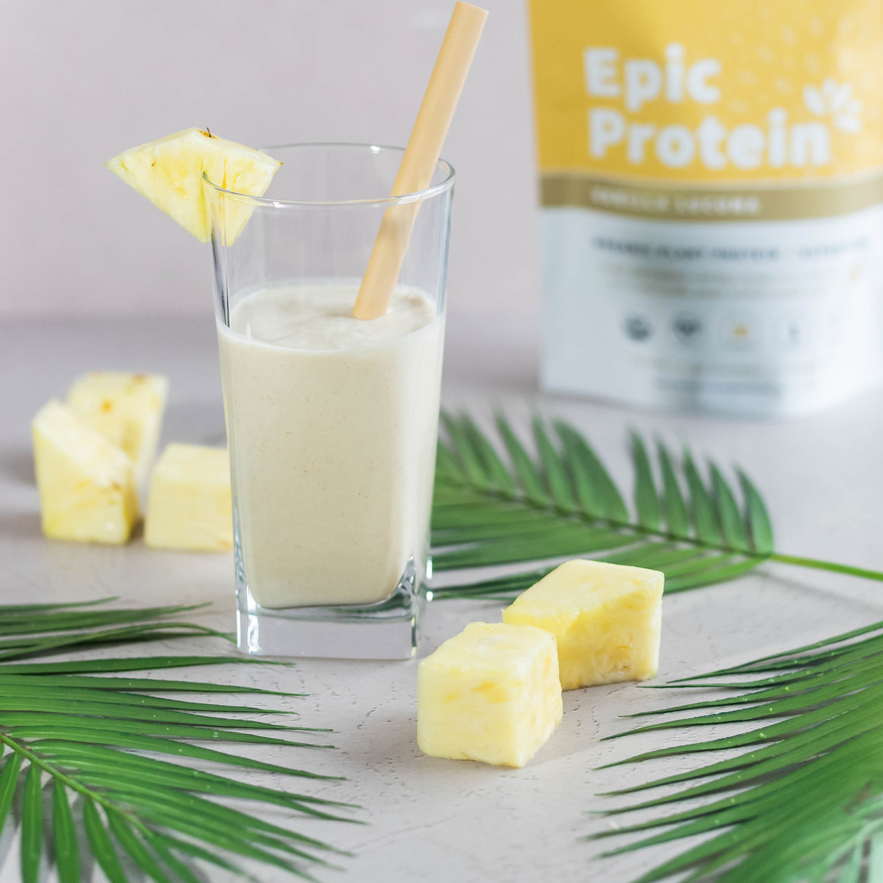 Pina Colada Protein Smoothie with palm leaves and Epic Vanilla Lucuma 1lb bag