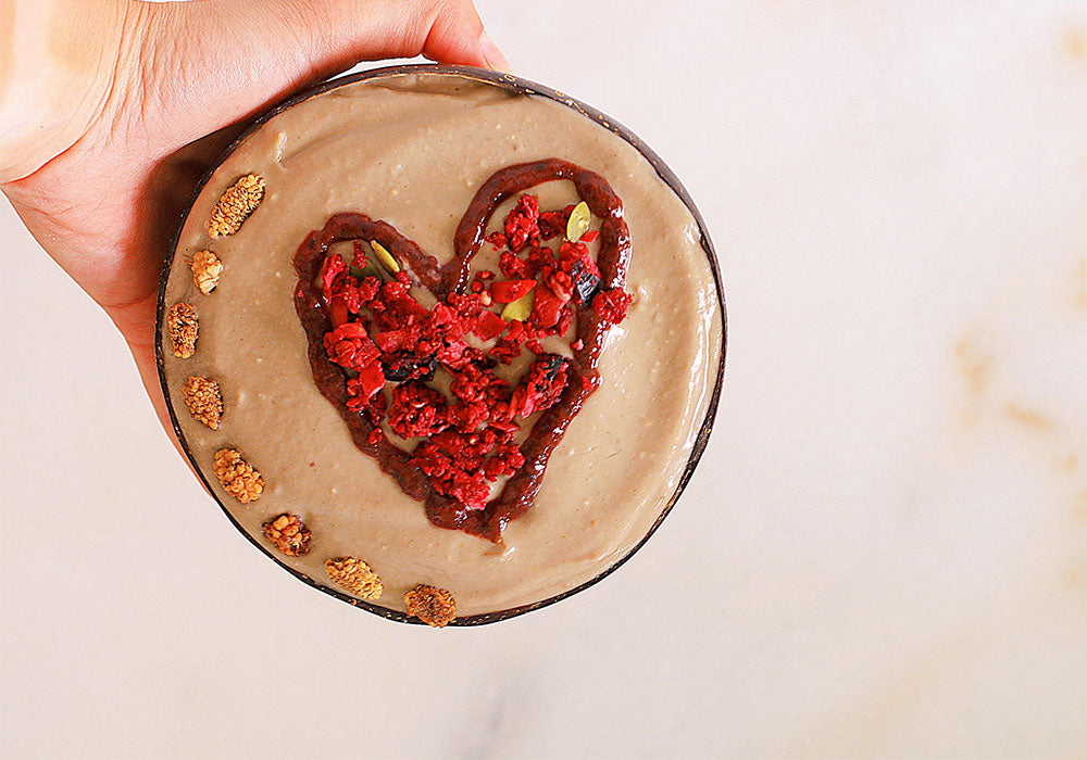 Hand holding Pear Maca Tahini Smoothie in bowl