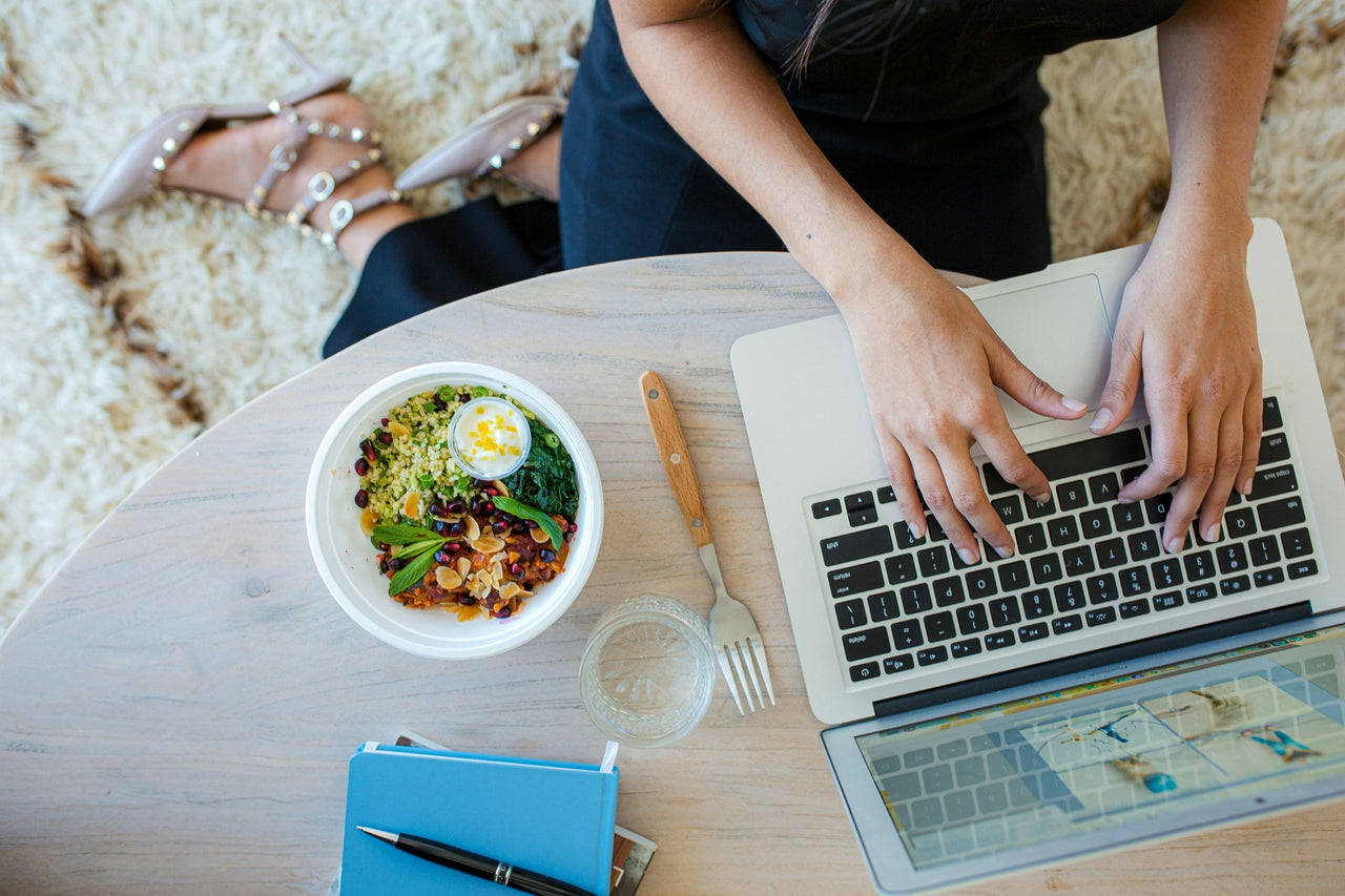 Woman at desk with computer and healthy lunch